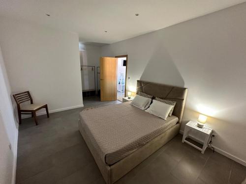 a bedroom with a bed and a table and a chair at Capelas Pdl Apartment in Ponta Delgada