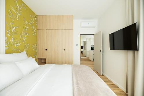 a bedroom with a bed and a flat screen tv at Lighthouse View - Sol Marina in Wiślinka