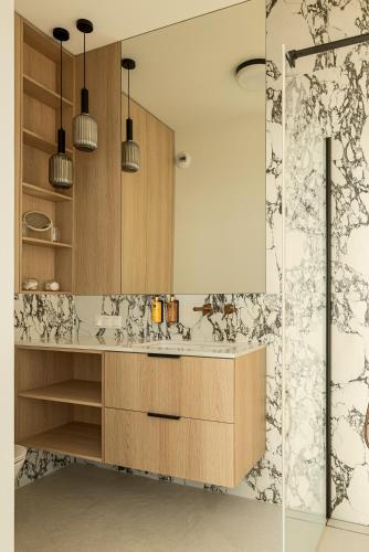 a bathroom with a sink and a shower at Lighthouse View - Sol Marina in Wiślinka