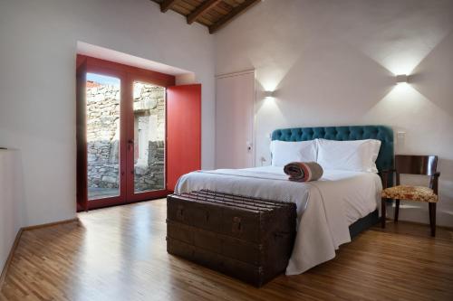 a bedroom with a bed with a suitcase on it at Casa Dr Ramiro Salgado - Douro Superior, Torre de Moncorvo in Torre de Moncorvo