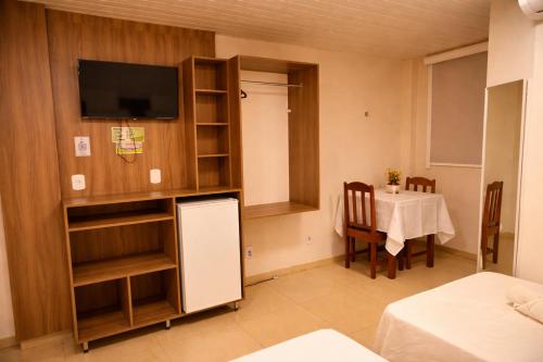 a kitchen and dining room with a table and a tv at Frota Palace Hotel in Macapá
