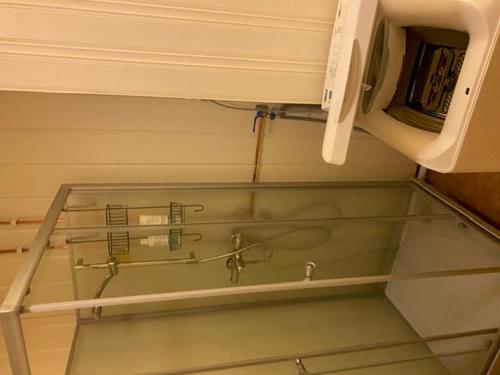 a glass shelf with a shower in a bathroom at Sentrumovernatting in Kjøllefjord
