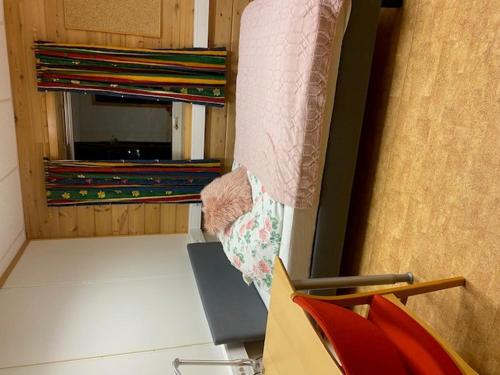 a room with a bed and a shelf with records at Sentrumovernatting in Kjøllefjord