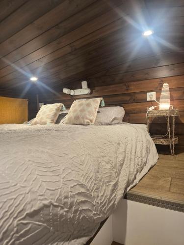 a bedroom with a bed with wooden walls and lights at La Perle des Sentiers in Rhisnes