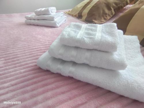 two white towels sitting on top of a bed at Rassvet in Lenīnogorsk