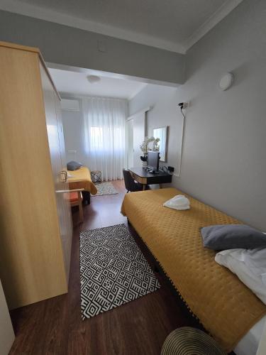 a hotel room with two beds and a desk at Hostel Jardins de São Luís in Setúbal