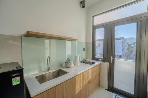 a kitchen with a sink and a large window at An Thy HOTEL in Vung Tau