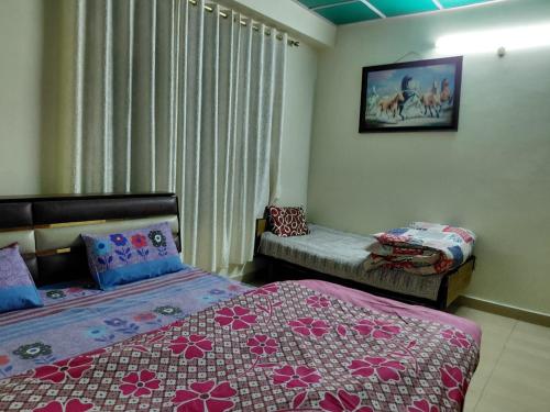 a bedroom with two beds and a window with curtains at Indu Homestay in Shimla