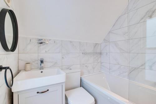 a bathroom with a sink and a tub and a toilet at 2 Bed in Looe oc-l30069 in Looe