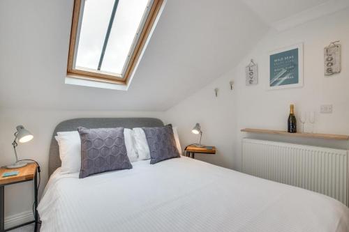 a bedroom with a white bed and a window at 2 Bed in Looe oc-l30069 in Looe