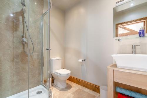 a bathroom with a shower and a toilet and a sink at 4 Bed in Thwing oc-t29013 in Thwing