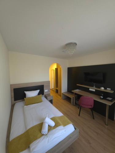 a bedroom with a bed and a desk with a television at Hotel zur Flüh in Bad Säckingen