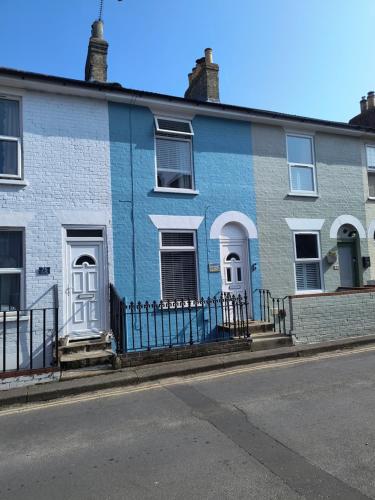 a blue and white house with a fence at Seabreeze Pet friendly 3 bedroom house by the sea in Gorleston-on-Sea