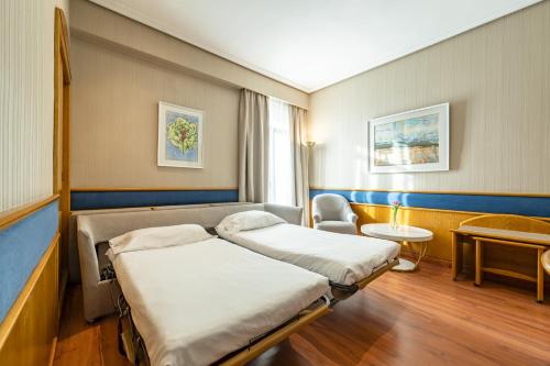 a hospital room with two beds and a chair at Agumar Atocha in Madrid
