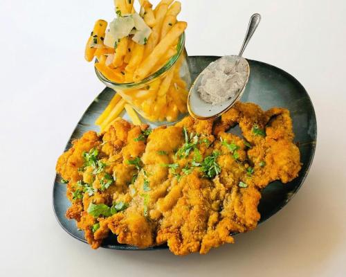 un piatto di cibo con patatine fritte e una ciotola di salse di Jaspers Boutique Rooms a Berlino