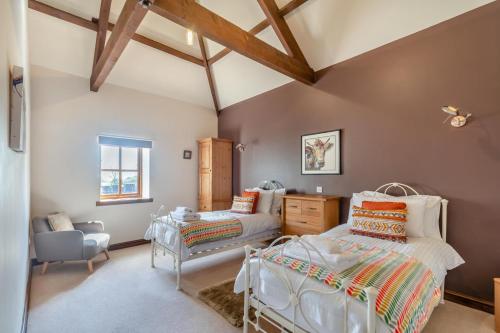a bedroom with two beds and a chair at 3 Bed in Thwing oc-t29011 in Thwing