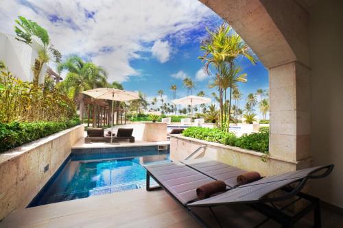 a pool at a resort with two chaise lounges at Royalton Hideaway Punta Cana, An Autograph Collection All-Inclusive Resort & Casino - Adults Only in Punta Cana