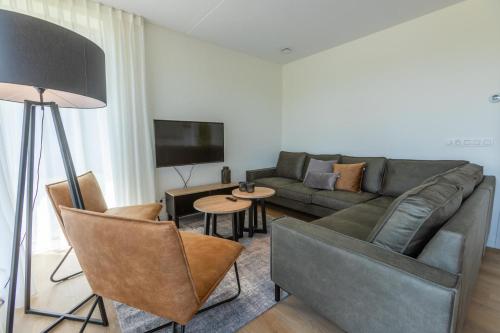 a living room with a couch and a tv at EuroParcs Cadzand-Bad in Cadzand