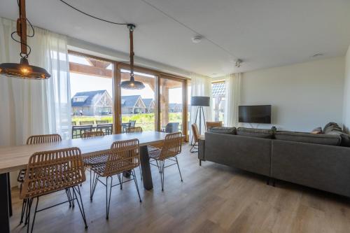 a living room with a couch and a table and chairs at EuroParcs Cadzand-Bad in Cadzand