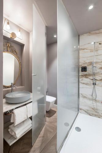 a bathroom with a glass shower and a sink at 19 Steps Trevi in Rome