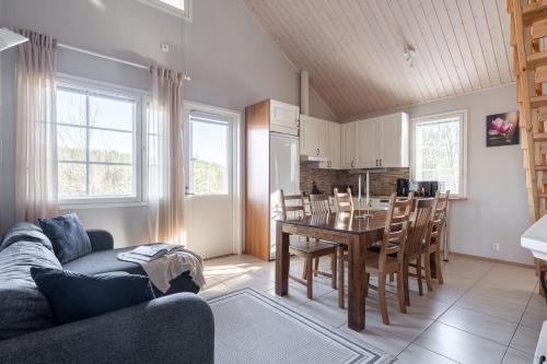 a living room with a table and a dining room at Villa Magnolia 2 Himos in Jämsä