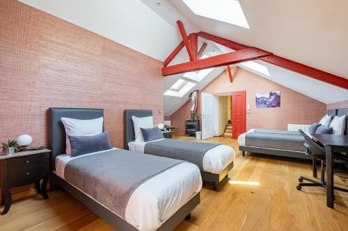 a bedroom with two beds and a desk in it at Cosy Loft in Nantes in Nantes