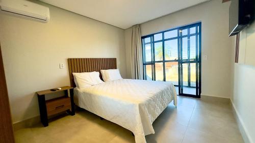 a bedroom with a bed and a large window at Essenza Living in Formosa