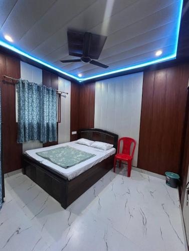 a bedroom with a bed and a red chair at anandam stay in Vrindāvan