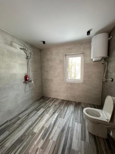 a bathroom with a toilet and a window at Forest Residens in Krasnik