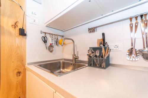 a kitchen with a stainless steel sink and utensils at The Little Cottage in Alleghe