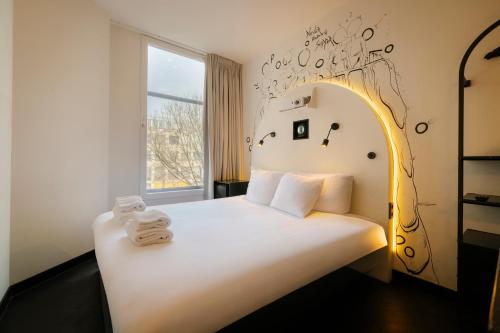 a bedroom with a white bed with towels on it at Supper Boutique Suites in Amsterdam