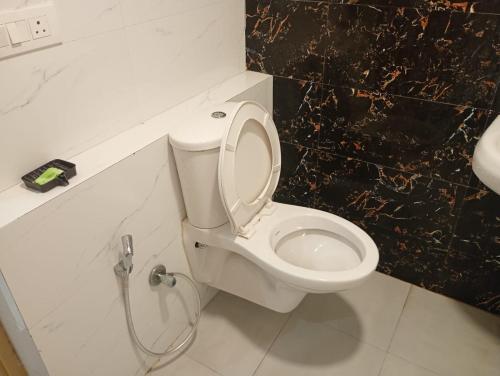 a bathroom with a white toilet and a sink at Hotel Vijay Palace in Agra