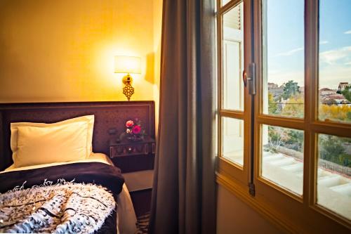 a bedroom with a bed next to a window at Villa Pomme d'Or in Midelt