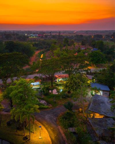 a sunset over a park with trees and buildings at PhuKasa Valley Maesot -Wellness Resort in Ban Mae Kasa