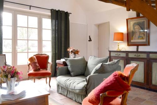 a living room with a couch and a chair at La Roseraie in Barjouville