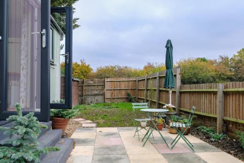 a patio with a fence and a table and an umbrella at 1 Bed in Raunds oc-s33685 in Raunds