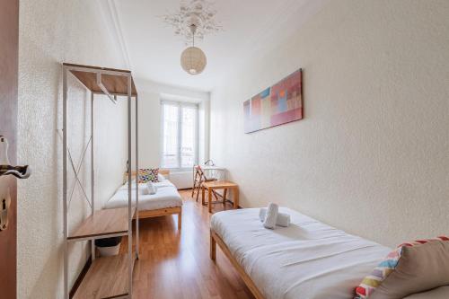 a small room with two beds and a table at Le Sebastopol - Appt moderne de 65m2 in Strasbourg