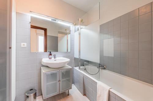 a white bathroom with a sink and a shower at Le Sebastopol - Appt moderne de 65m2 in Strasbourg