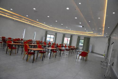 a dining room with tables and red chairs at RICEM Guest House in Cyuve