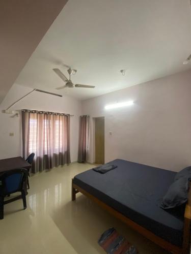 a bedroom with a bed and a chair in it at Southern Cliff House in Varkala