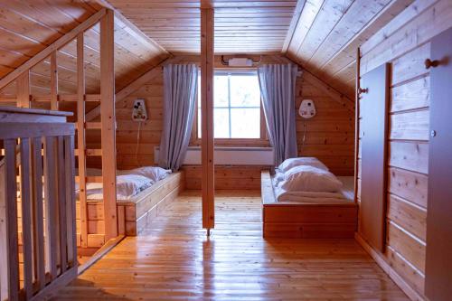 a room with two beds in a wooden cabin at Syötekätkö in Syöte
