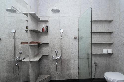a bathroom with a glass shower with a toilet at DrUnni's Ayurveda Resort in Kovalam
