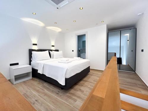 a bedroom with a large bed and a wooden floor at MY Sunset Suite in Kuşadası