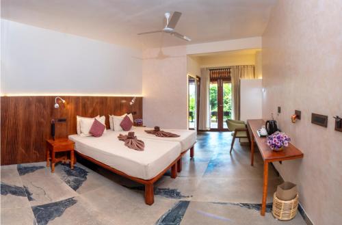 a bedroom with a bed and a desk in it at DrUnni's Ayurveda Resort in Kovalam