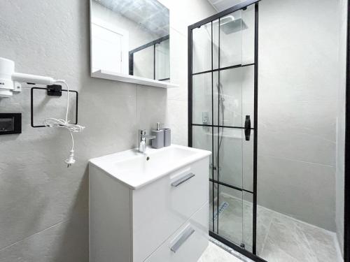a white bathroom with a sink and a shower at MY Sunset Suite in Kuşadası