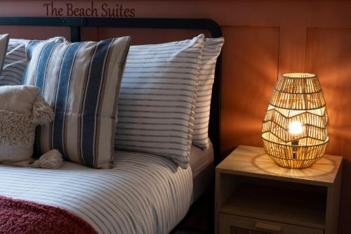 a bed with a lamp on a night stand next to a bed at Central Apartment- Stunning Sea Views- 100m to Beach- Sleeps 6 in Newquay