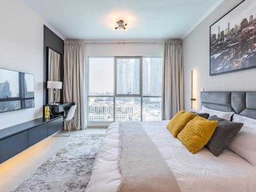a bedroom with a large bed with a large window at the 'New York' Condo - 4BR Executive Burj Khalifa Suite in Dubai