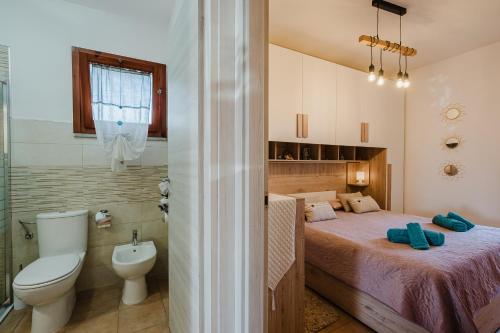 a bedroom with a bed and a toilet and a bathroom at villetta giulia fronte mare in Stintino