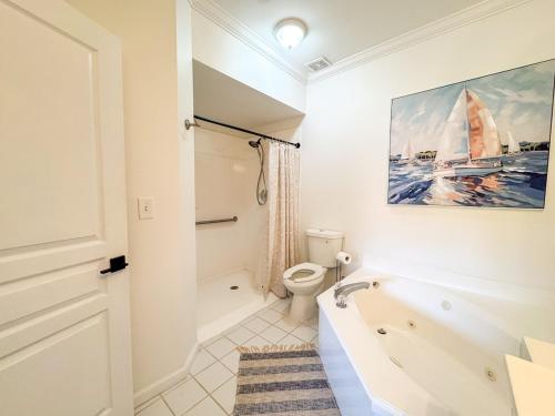 a bathroom with a bath tub and a toilet at Destin Harbor Escape in Destin