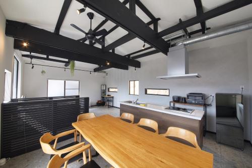 a dining room with a wooden table and chairs at リノベーションされた一軒家で富士山と自然 BBQを満喫 villa voyage in Azagawa